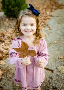 little girl with maple leaf